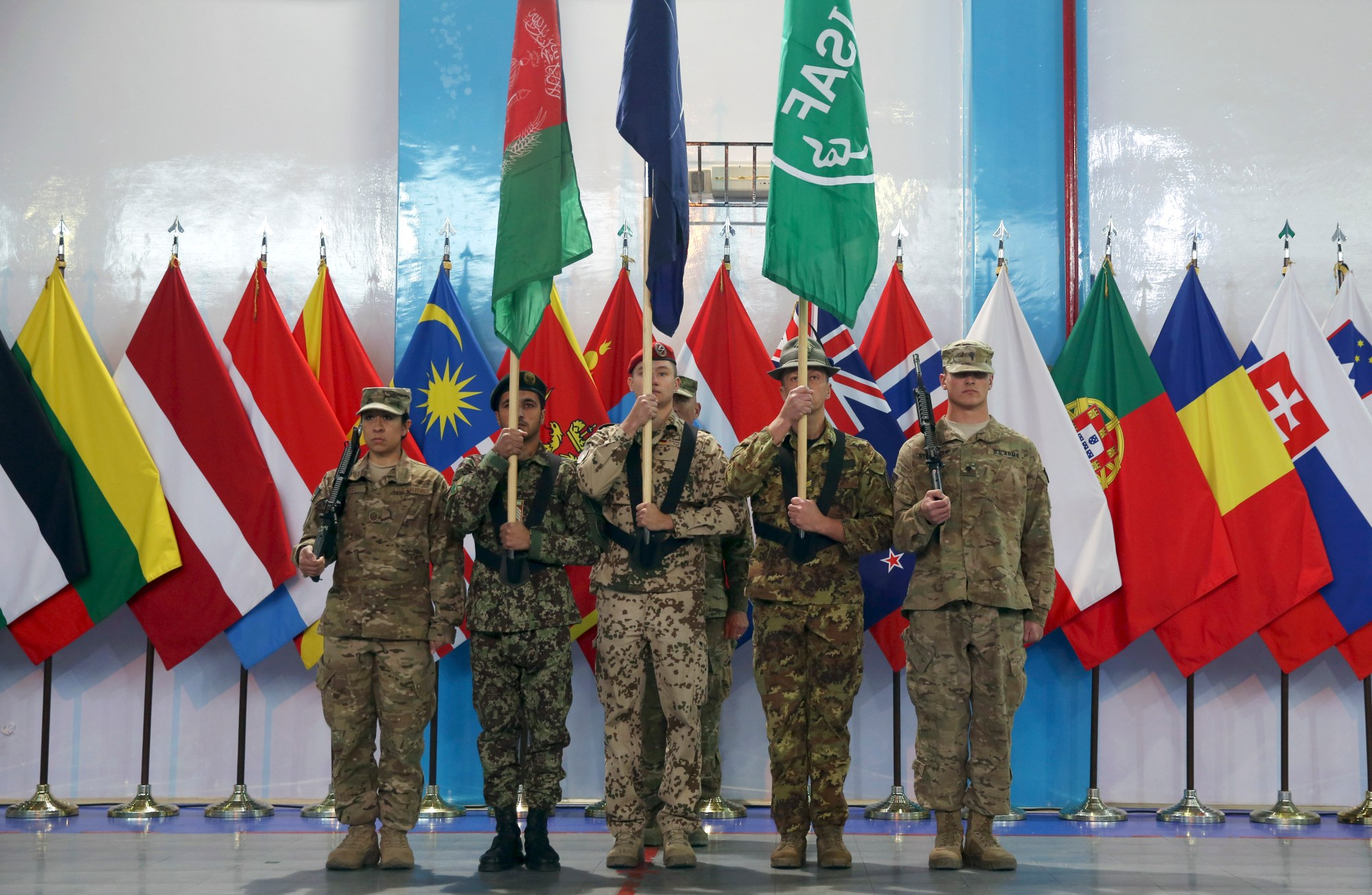 Afghan and international soldiers stand at attention during a ceremony at the headquarters of the U.S.-led International Security Assistance Force in Kabul, Afghanistan, Sunday, Dec. 28, 2014. The United States and NATO formally ended their war in Afghanistan on Sunday with the ceremony at their military headquarters in Kabul as the insurgency they fought for 13 years remains as ferocious and deadly as at any time since the 2001 invasion that unseated the Taliban regime following the Sept. 11 attacks. (AP Photo/Massoud Hossaini)
