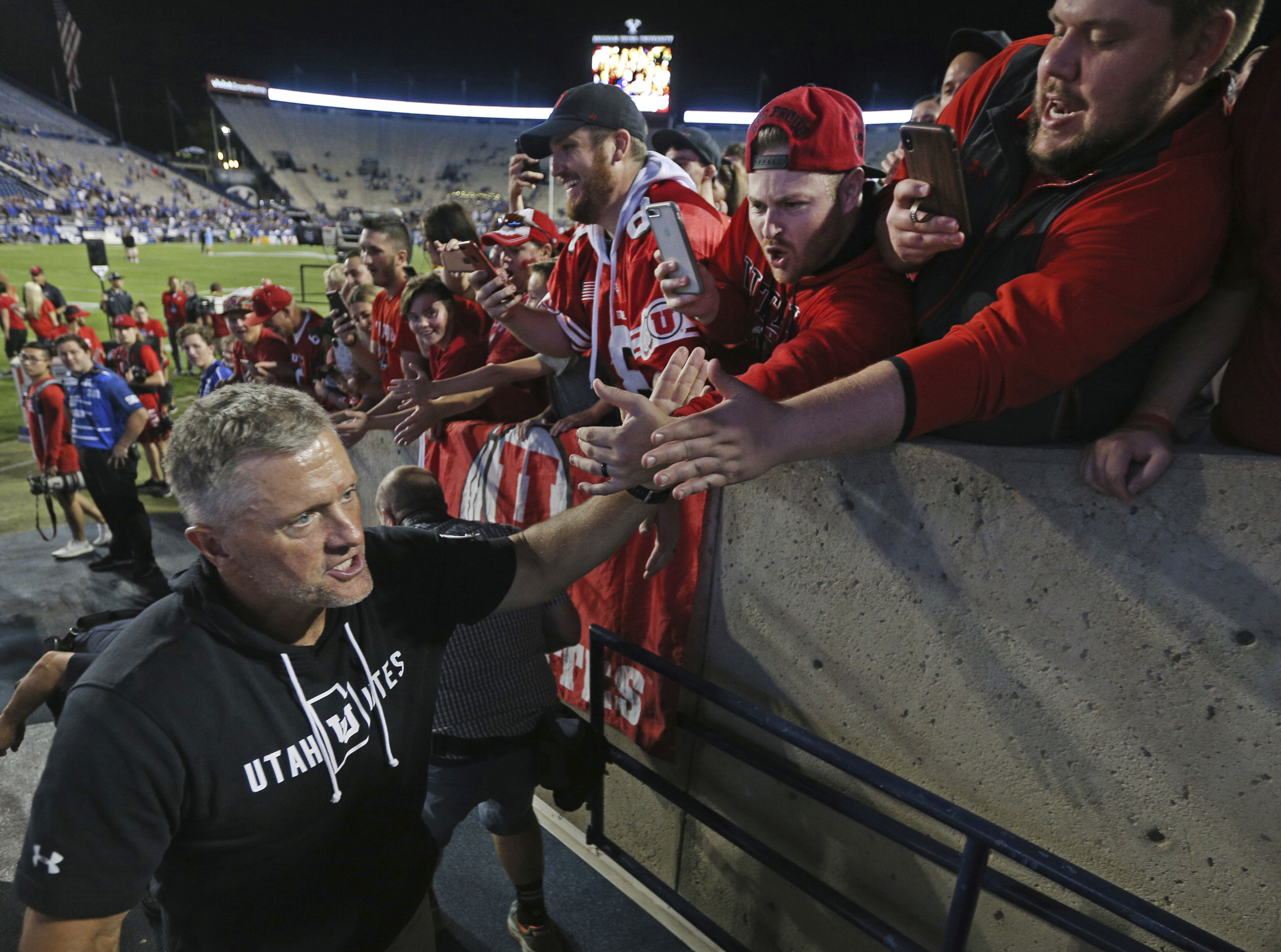 Utah head coach Kyle Whittingham greets fans after defeating BYU at an NCAA college football game, Thursday, Aug. 29, 2019, in Provo, Utah. Utah defeated BYU 30-12. (AP Photo/George Frey)