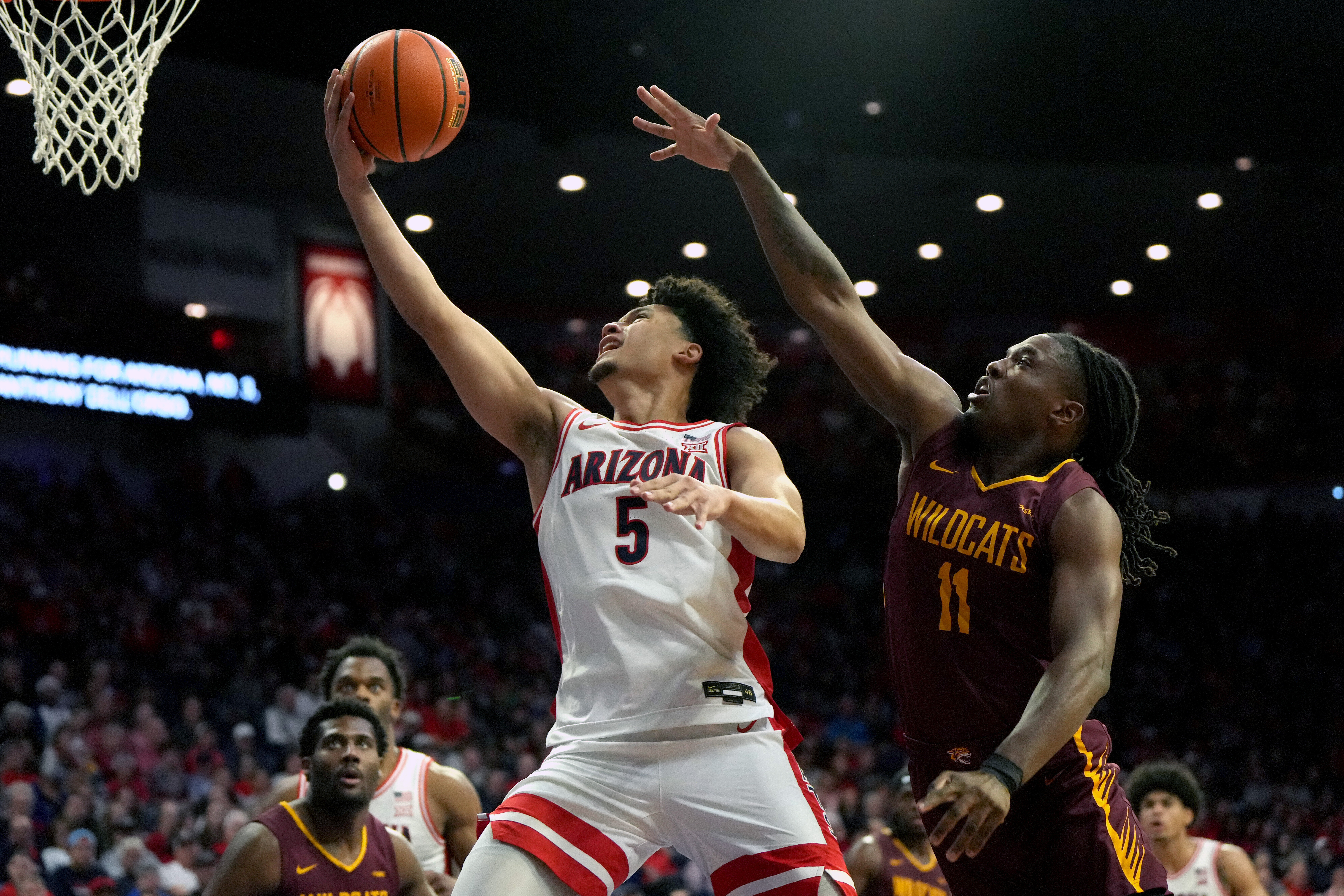 Arizona guard Brayden Burries (5) drives past Bethune-Cookman guard Jordan Johnson (11) during the second half of an NCAA college basketball game, Monday, Dec. 22, 2025, in Tucson, Ariz. (AP Photo/Rick Scuteri)