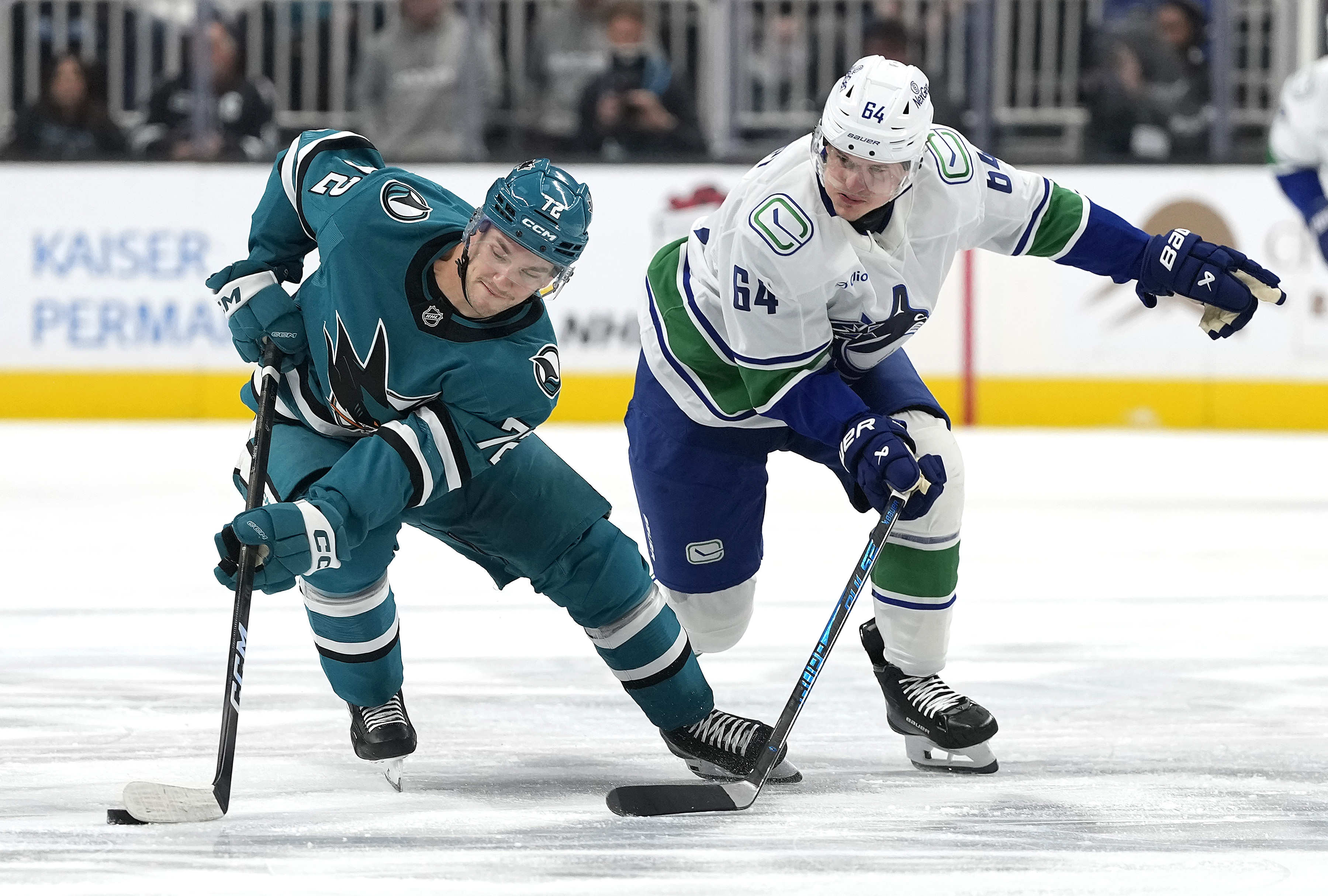 SAN JOSE, CALIFORNIA - NOVEMBER 28: William Eklund #72 of the San Jose Sharks and David Kampf #64 of the Vancouver Canucks battle for control of the puck in the first period at SAP Center on November 28, 2025 in San Jose, California. (Photo by Thearon W. Henderson/Getty Images)