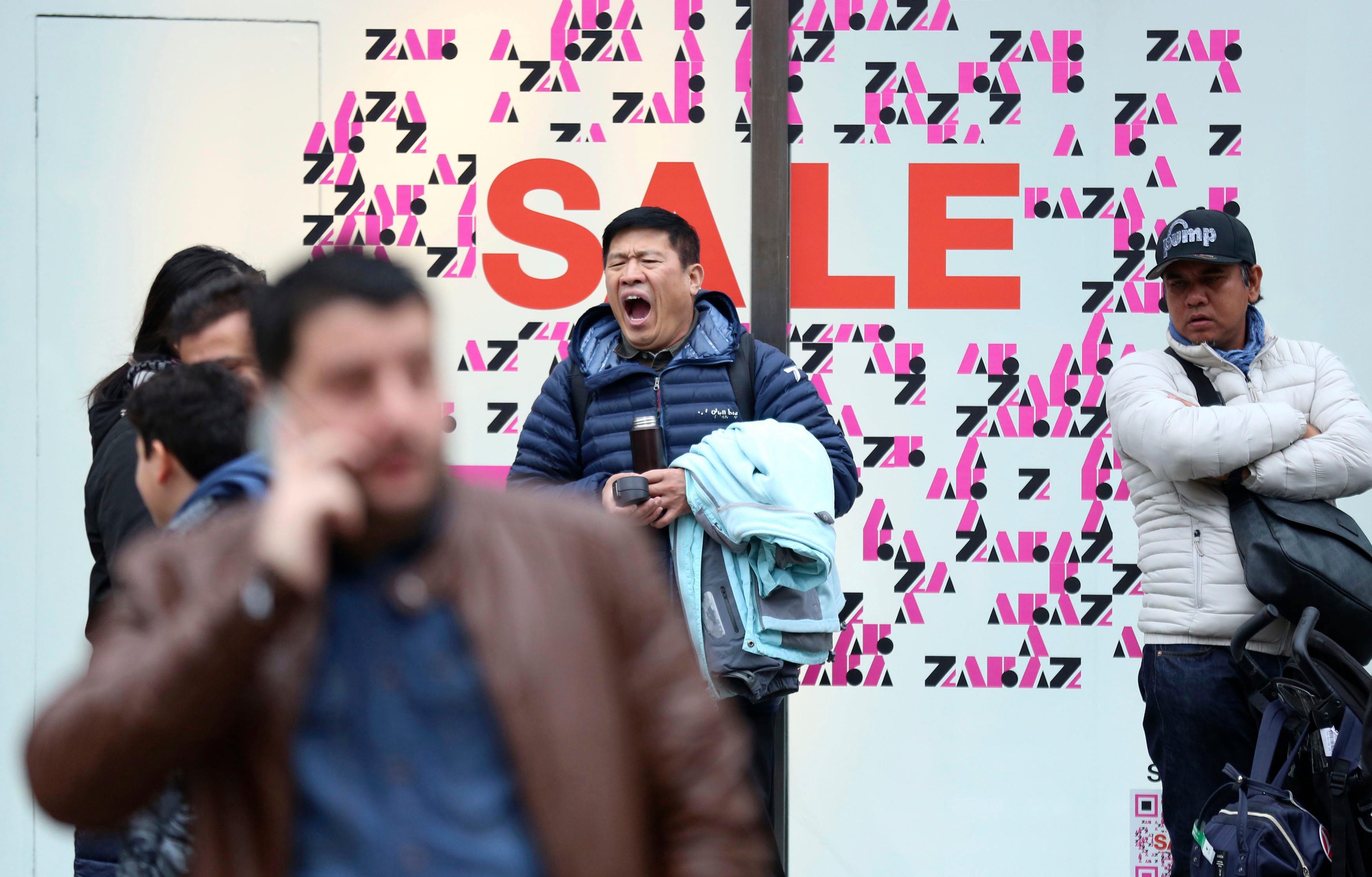 Britain_Sales_22673 A shopper yawning while waiting outside a shop, during the Boxing Day sales, on Oxford Street, in London, Wednesday, Dec. 26, 2018. (Isabel Infantes/PA via AP)