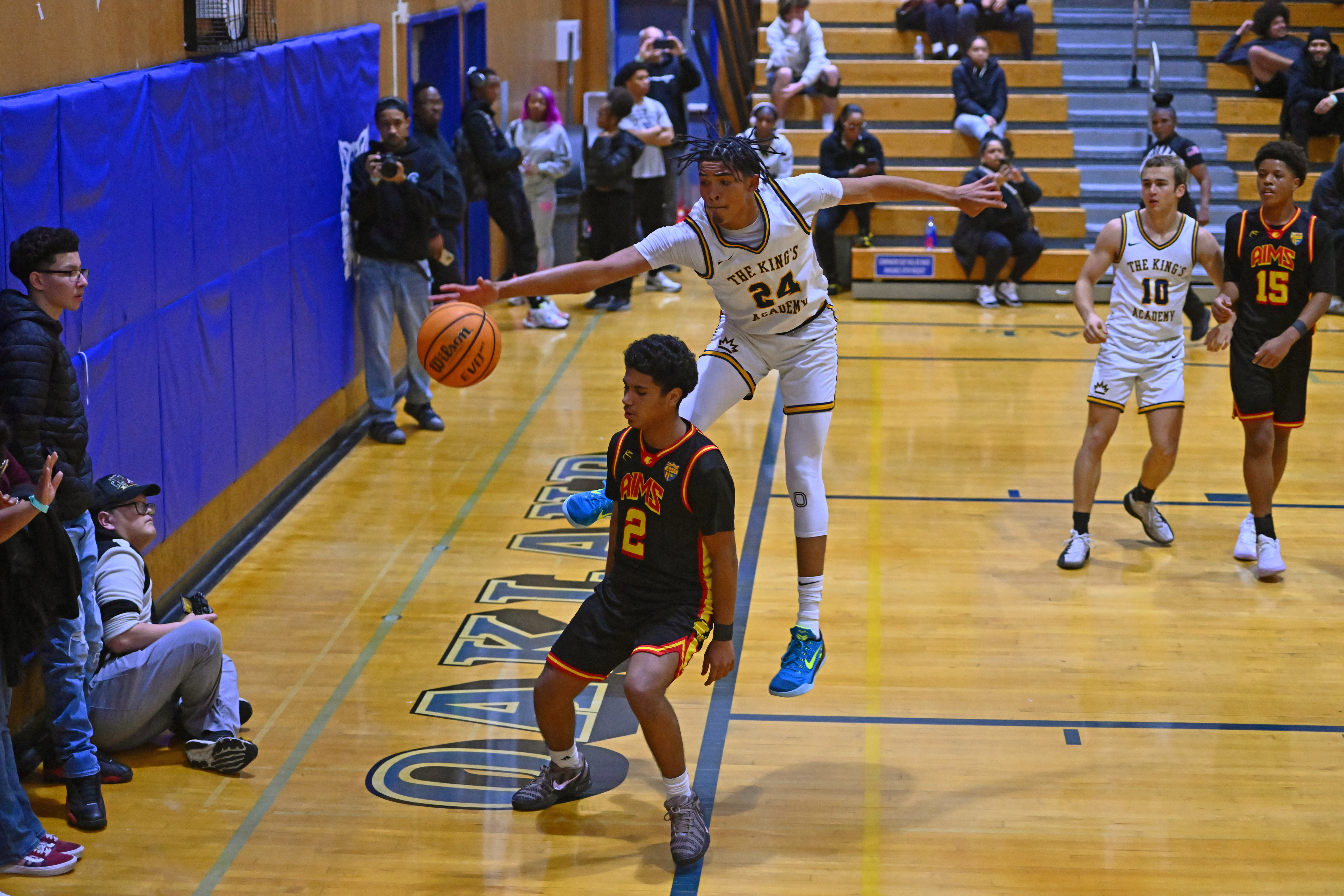 King's Academy’s Boss Mhoon (24) attempts to save an out of bounds ball over AIMS College Prep’s Amr Aldhanebi (2) in the second period of their game during the Damian Lillard Classic at Oakland High School in Oakland, Calif., on Friday, Dec. 26, 2025. King's Academy defeated AIMS 93-25. (Jose Carlos Fajardo/Bay Area News Group)